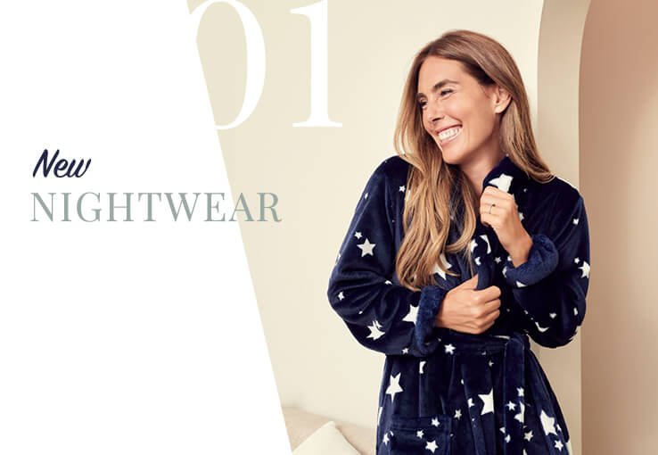 A smiling woman wearing a navy starry pyjama set.
