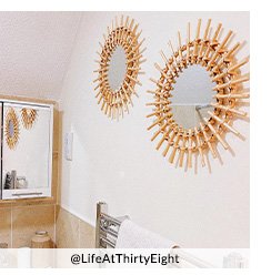 A bathroom wall with two starburst mirrors