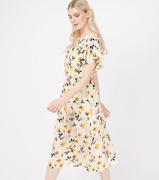 Woman wearing a cream floral print midi dress