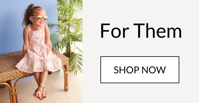 Girl sat on a bench wearing a pink sun dress and sunglasses