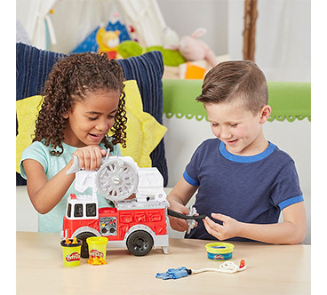 A girl and boy playing with a Play-Doh fire truck toy