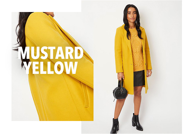 Model wearing yellow longline formal coat with a matching jumper, black skirt and boots