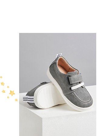 Billie Faiers First Walkers grey canvas shoes on a white plinth