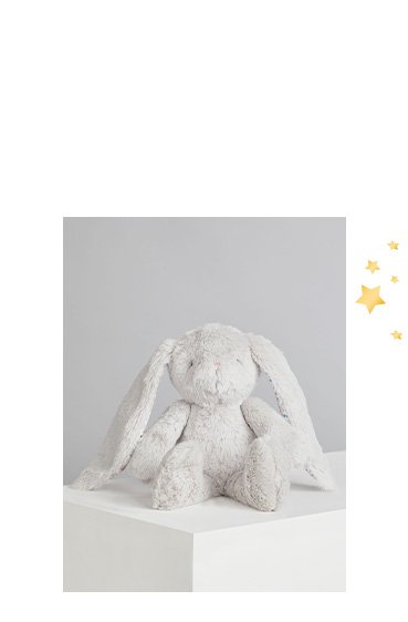 Billie Faiers grey faux fur floral floppy ear plush bunny toy on a white plinth