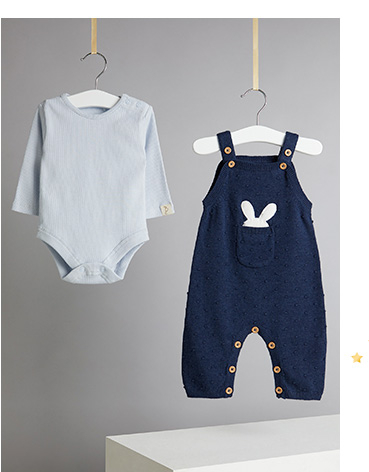 Product shot of dungarees and blue top on hangers