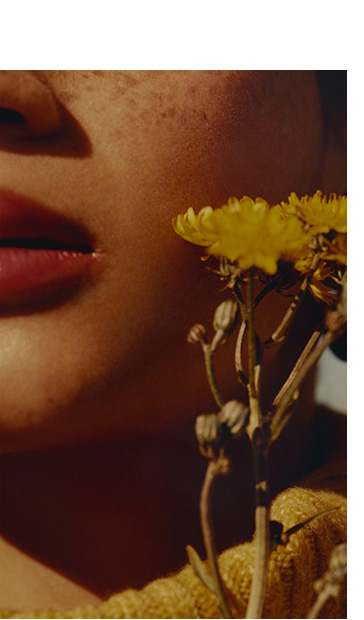 Close up of woman's cheek with yellow flowers 