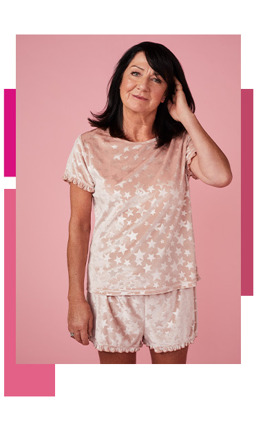 Woman wearing a pink pyjama set designed with stars 