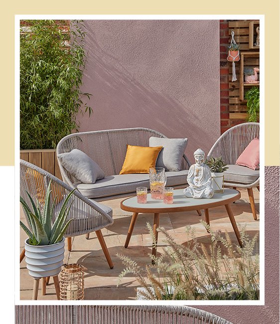 A patio with a Nerja 4 piece outdoor sofa set with cushions and ornaments