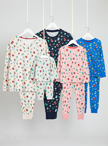 Grey, navy, pink and blue matching pyjamas with Christmas icons, all on hangers hanging from string