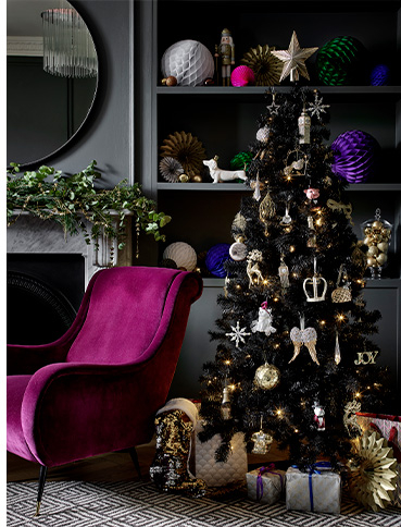 Christmas tree decorated with golden baubles and ornaments with presents underneath
