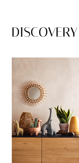 Wooden table with animal ornaments, pots, plants and a gold mirror on the wall 