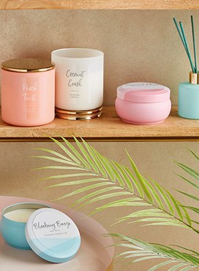 A variety of scented candles in colourful pots on a shelf