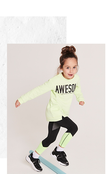 Girl jogging wearing neon green 'Awesome' slogan sports top, matching bottoms and black gym trainers