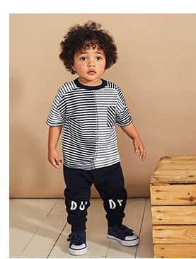 Boy wearing striped blue top, navy bottoms and navy trainers