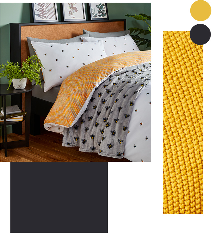 Double bed with reversible bumblebee print bedding, a matching grey throw and an artificial plant on a bedside table
