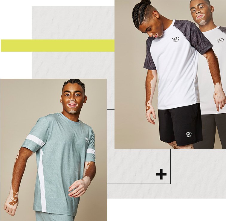 Man poses looking down wearing WRKOUT white printed sports t-shirt and black jersey shorts. Man poses wearing WRKOUT sage striped t-shirt and jersey shorts outfit.