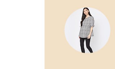 Woman with long dark hair poses wearing maternity grey checkered blouse with maternity black over the bump ponte leggings.