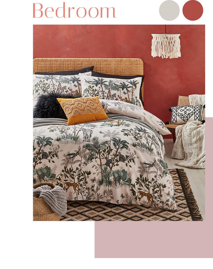 Double bed with jungle print bedding, a grey knitted throw, a black faux fur cushion and an ochre patterned cushion