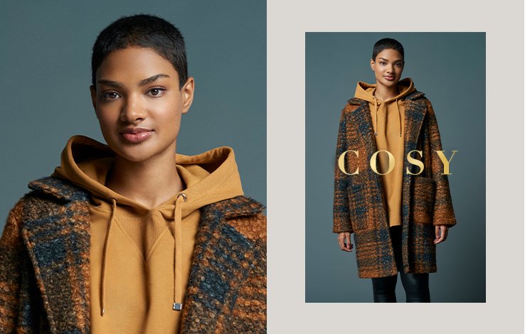 Close up of woman with short dark hair wearing black and burnt orange printed coat layered over light brown hoodie next to a zoomed-out version of her wearing black and burnt orange printed coat layered over light brown hoodie and jeans with 'cosy' gold lettering overlayed.