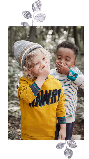 Two boys laughing covering their mouth wearing long sleeve tops