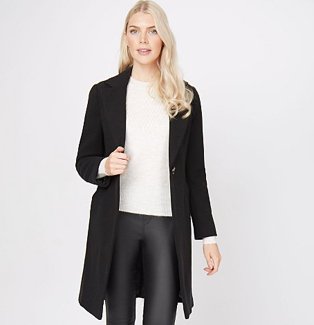 Woman wearing a black longline formal coat with a white top and black jeans