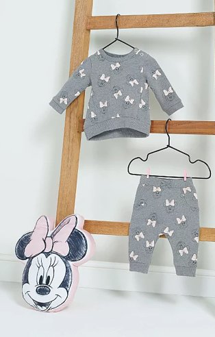 Disney Minnie Mouse grey sweatshirt and joggers outfit hanging from wooden ladder with pink Minnie Mouse cushion below.