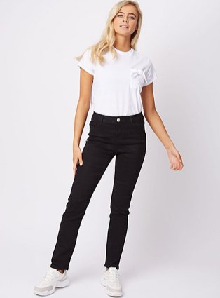 Blonde woman posing wearing white crew neck t-shirt, black jeans and white trainers.