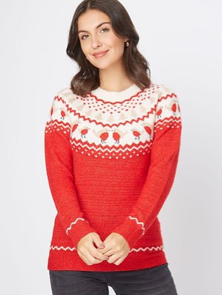 Brunette woman poses wearing red fairisle robin knitted Christmas jumper and black jeans.