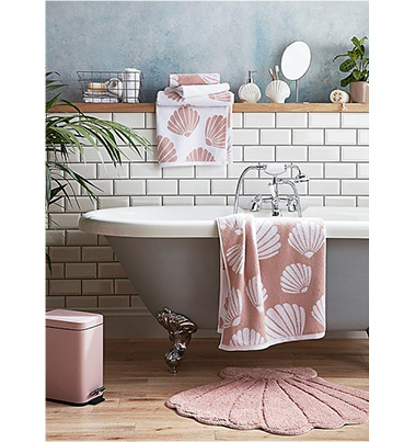 Grey bath with pink seashell towels and bathroom accessories 