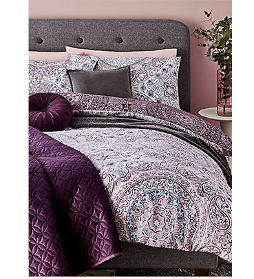 Purple printed duvet set with pillows and a purple throw 