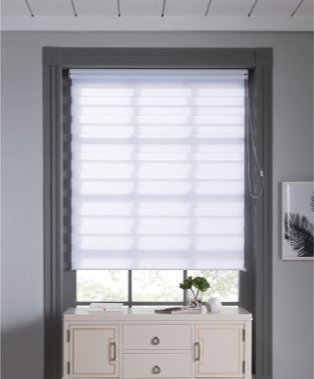 Large grey bathroom window features white blind with white storage unit below.