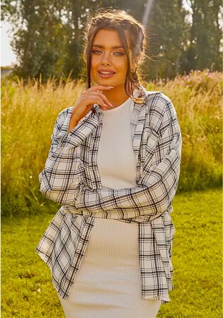 Woman poses in field wearing G21 white knit ribbed midi dress and G21 white oversized check shirt.