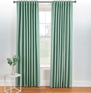 Large white window with green eyelet curtains on silver-tone curtain rail.