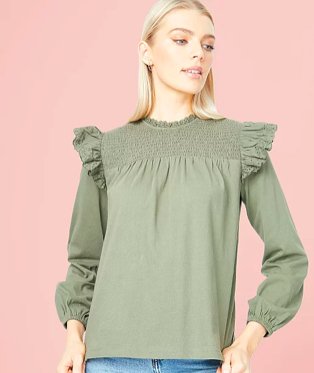 Woman poses wearing khaki frill trim long sleeve blouse.