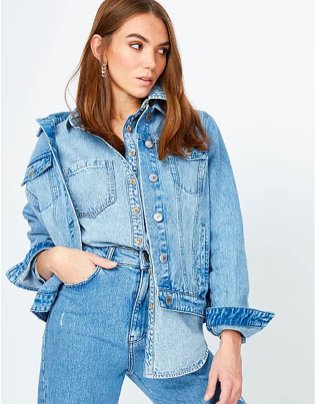 Woman poses with hand in pocket wearing denim shirt, light wash denim jacket and jeans.