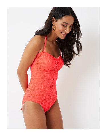 A crochet overlay, flattering fit and neon coral colouring make this swimsuit a total knockout