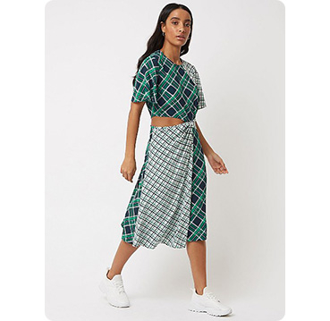 Woman wearing green check cut out waist midi dress