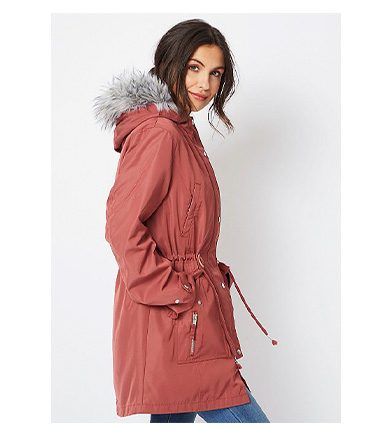 Woman wearing dusty pink faux fur removable inner longline parka