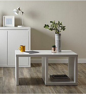 White table with plant pot, yellow mug and succulent plant on top 