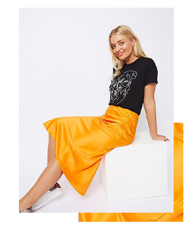 Match a vibrant orange satin look midi skirt with a black top
