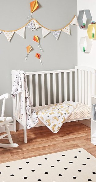 White and grey baby nursery features white Rafferty cot bed with Disney Lion King bedding, bunting and monochrome polka dot rug.