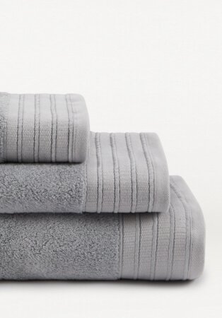 Stack of light grey hand towel, bath towel and bath sheet.