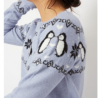 Close up shot of blue jumper with penguins and snowflakes 