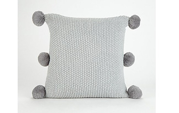 Light grey textured cushion with pom poms