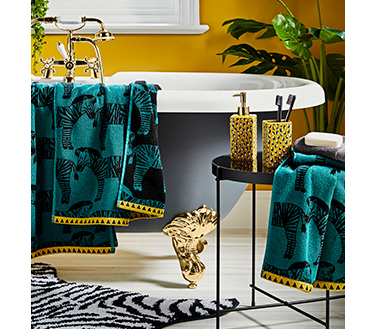 Bathroom featuring green zebra print towels and yellow leopard print accessories