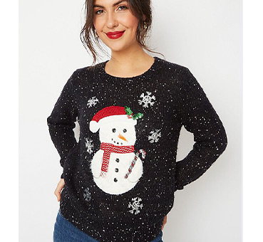 Woman wearing a black sparkly jumper with a snowman surrounded by snowflakes