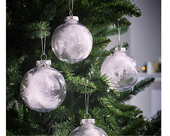 Close up of Christmas tree with clear baubles containing white feathers