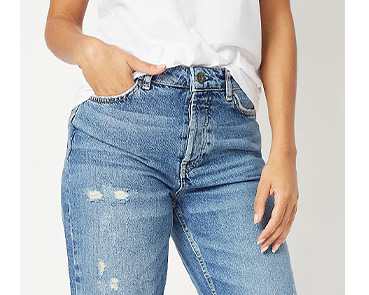 Close up shot of woman wearing a white T-shirt tucked into blue jeans 