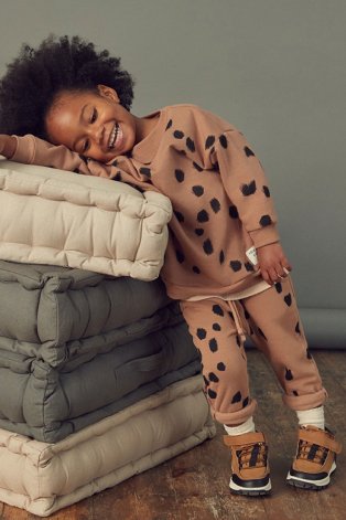 Child wearing unisex brown spotted loungewear suit.
