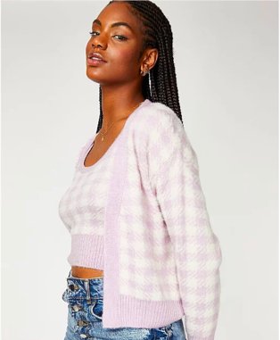 Woman poses side-on wearing lilac gingham knitted top and co-ord cardigan set and blue high-rise jeans.